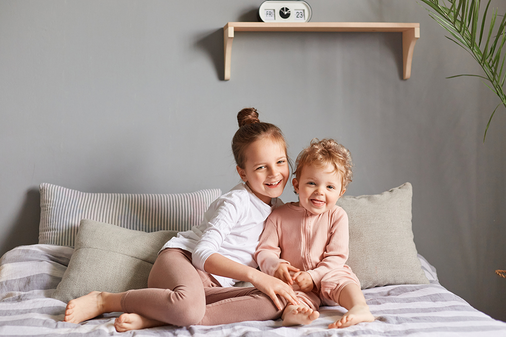 Happy little girls playing on bed